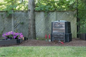 Compost Bin situated on the ground near a tree.